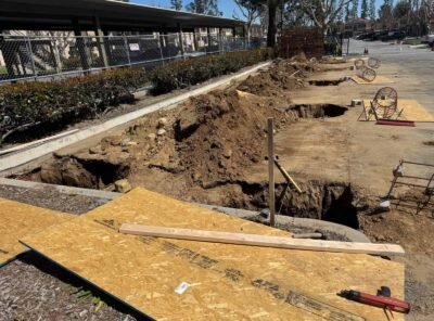Construction site with dug-up ground and equipment.