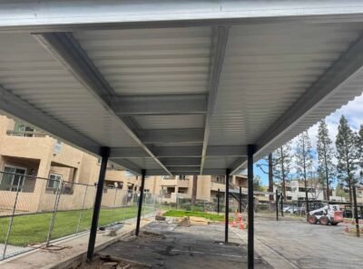 View of a metal-covered parking area under construction