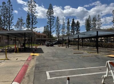 Construction site with covered parking and trees.